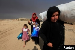 Displaced people who are fleeing from clashes arrive in Qayyarah, during an operation to attack Islamic State militants in Mosul, Iraq on Oct. 19, 2016.