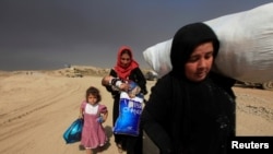 A family arrives in Qayyarah during an operation to attack Islamic State militants in Mosul, Iraq on Oct. 19, 2016.