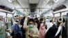 Penumpang mengenakan masker, berdiri di dalam kereta komuter pada jam sibuk sore hari di tengah merebaknya varian omicron di Jakarta, 3 Januari 2022. (REUTERS/Willy Kurniawan)