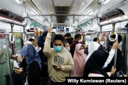 Penumpang yang memakai masker pelindung berdiri di dalam kereta komuter pada jam sibuk sore hari saat varian omicron terus menyebar, di tengah pandemi COVID-19, di Jakarta, 3 Januari 2022. (Foto: REUTERS/Willy Kurniawan)