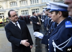 French President Francois Hollande shakes hands to police officers at the Paris' police headquarters, Jan. 7, 2016, one year after the attack targeting the French satirical newspaper Charlie Hebdo.