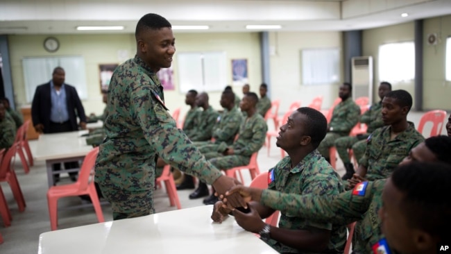 A member of Haiti's new national military force greets a fellow soldier in a meeting room at a former U.N. base in Gressier, Haiti, April 11, 2017.