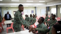 A member of Haiti's new national military force greets a fellow soldier in a meeting room at a former U.N. base in Gressier, Haiti, April 11, 2017.