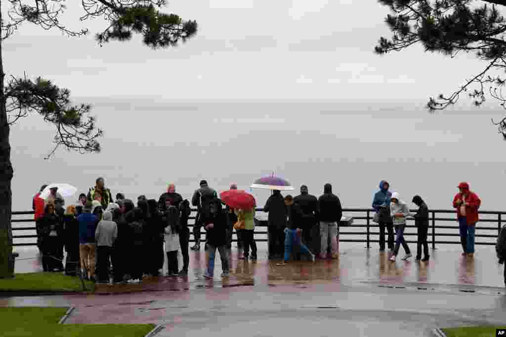 Visitors look at Omaha Beach from the Normandy American Cemetery and Memorial, in Colleville sur Mer, France, June 4, 2014.