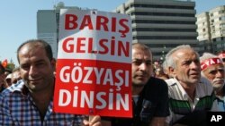 FILE - Thousands of Alevi Muslims, members of Turkey's largest religious minority group, with some holding banners that read "Let's make peace and stop bloodshed" rally in Ankara.