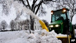 Snow is removed from the driveway at the White House in Washington. 