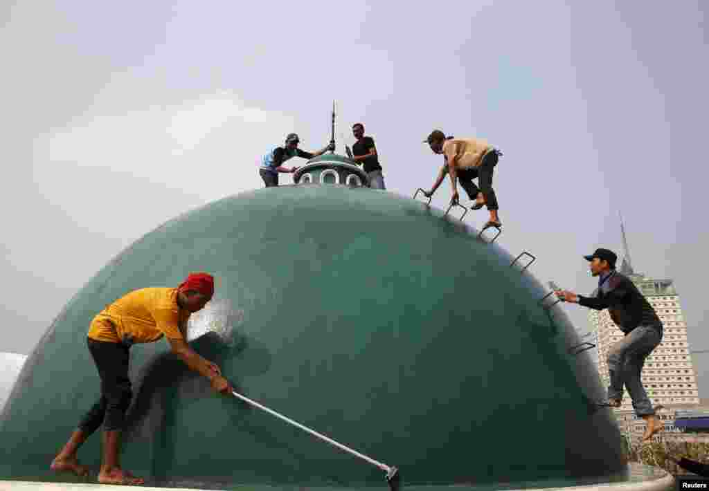 Youths clean a dome of a mosque ahead of the upcoming holy fasting month of Ramadan in Jakarta. Ramadan in Indonesia will start on June 18, a local paper reported.