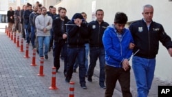 FILE - Police officers escort people arrested because of suspected links to U.S.-based cleric Fethullah Gulen, in Kayseri, Turkey, April 26, 2017. Ankara suspects Gulen of masterminding a July 2016 coup attempt.