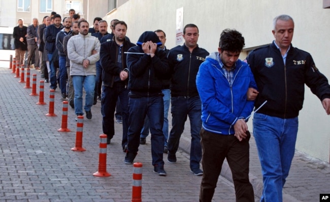 FILE - Police officers escort people, arrested because of suspected links to U.S.-based cleric Fethullah Gulen, in Kayseri, Turkey, April 26, 2017.