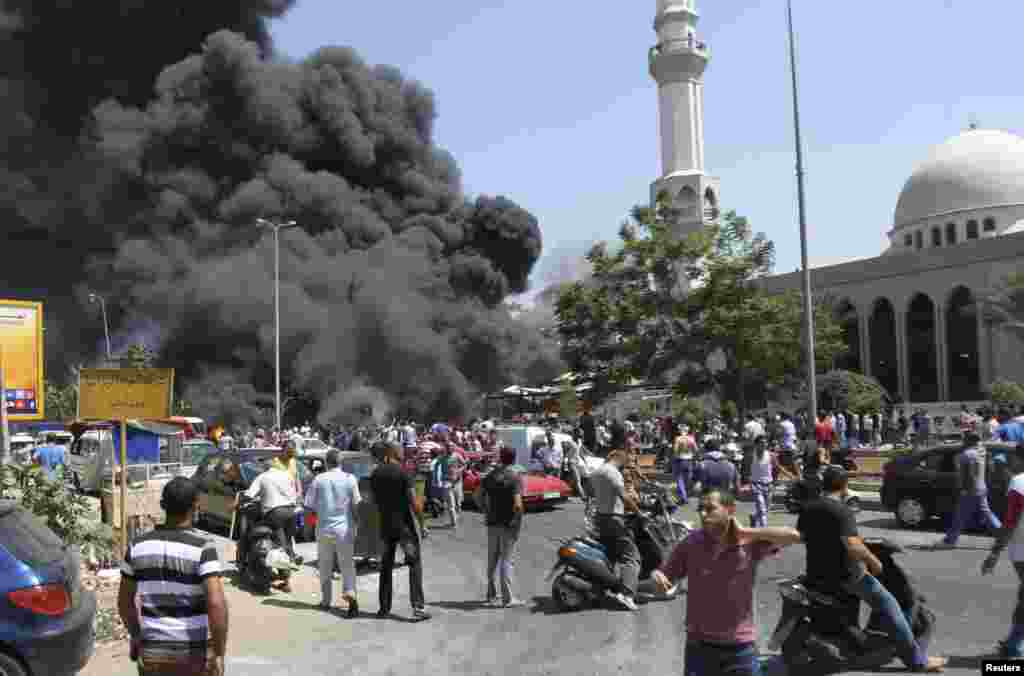 Smoke rises outside al-Taqwa mosque, one of two mosques hit by explosions, Tripoli, Lebanon, August 23, 2013.