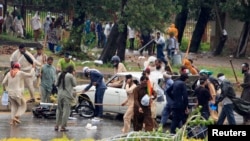Para demonstran menggunakan tongkat untuk menghantam mobil dan motor dalam protes di Islamabad (1/9). (Reuters/Faisal Mahmood)