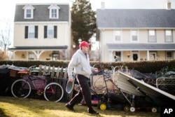 John Buckley, a Republican who relies on disability benefits and voted for Donald Trump, moves scrap metal at his home in Malvern, Pennsylvania.