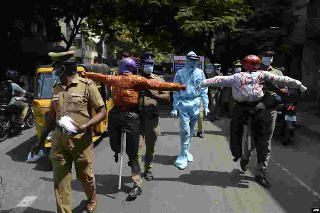 Policemen hold effigys of demons representing COVID-19 during an awareness campaign along a street in Chennai, as India surged past 13 million coronavirus cases.