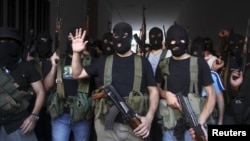 Shi'ite masked gunmen from the Mekdad clan gather at the Mekdad family's association headquarters in the southern suburbs in Beirut, Lebanon, August 15, 2012.