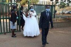 A bride and groom arrives to get married at the magistrates court, in Harare, Wednesday, Aug. 12, 2020. (AP Photo/Tsvangirayi Mukwazhi)