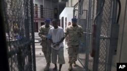 Detainee is escorted by guards inside Camp 6, a high-security detention facility at Guantanamo Bay U.S. Naval Base, Cuba., 30 Mar 2010 (file photo).