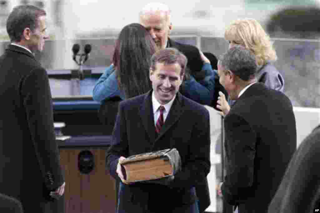 Beau Biden talks with President Barack Obama on the West Front Lawn of the Capitol in Washington after his father, Vice President Joe Biden (in background) took his ceremonial oath during the 57th Presidential Inauguration, Jan. 21, 2013.