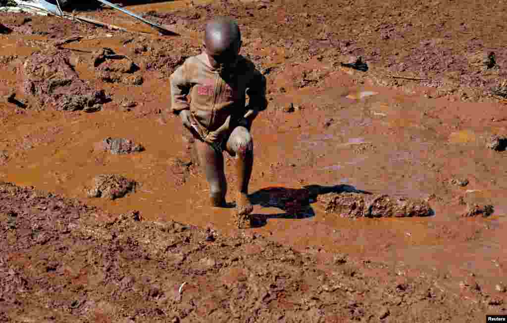 A child walks near houses destroyed by flood waters after a dam burst, in Solio town near Nakuru, Kenya.