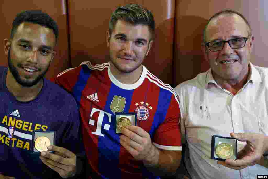Three men who helped to disarm an attacker on a train from Amsterdam to France, (left to right) Anthony Sadler, from Pittsburg, California, Alek Skarlatos from Roseburg, Oregon, and Chris Norman, a British man living in France, pose with medals they received for their bravery at a restaurant in Arras, France, Aug. 22, 2015.