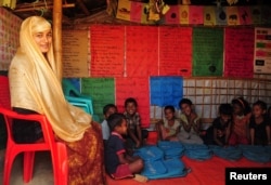 Nur Jahan, sister of Formin Akter, a Rohingya refugee girl, sits with her students inside her shelter, where she teaches, at the Kutupalong refugee camp in Cox's Bazar, Bangaldesh Dec. 4, 2018.