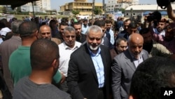 Ismail Haniyeh, new Hamas leader, center, shakes hands with a crowd member upon his arrival to a solidarity tent for hunger-striking Palestinian prisoners held by Israel, at the main square in Gaza City, May 8, 2017.