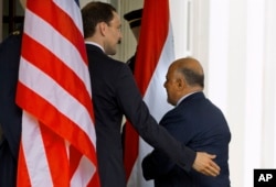 Iraqi Prime Minister Haider al-Abadi is welcomed into the West Wing of the White House in Washington, April 14, 2015, for his meeting with President Barack Obama and Vice President Joe Biden.