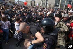 Russian police detain protesters at a demonstration against President Vladimir Putin in Pushkin Square as Russians angered by the impending inauguration of Vladimir Putin to a new term as the country's president demonstrated throughout the country on Satu