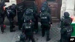 In this UGC image made from a mobile phone, police in riot gear surrounded the entrance of a building in central Paris where a man is believed to be holding two people hostage, in Paris, June 12, 2018. 