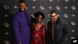 FILE - Actors Winston Duke, from left, Lupita Nyong'o and director Jordan Peele pose for photographers upon arrival at the premiere of the film 'Us' in London, March 14, 2019.