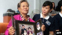 Bà Suharni, người Indonesia, cầm chân dung con trai và vợ, cả hai đều có mặt trên chuyến bay Malaysia bị mất tích, ngày 10/3/2014. 