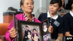 Grieving Indonesian mother Suharni displays a portrait of her son Sugianto Lo and wife Vinny Chynthya who are both passengers of the missing Malaysia Airlines flight, March 10, 2013.