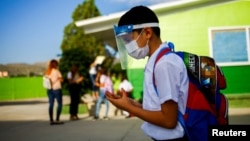 A student wearing a protective mask enters a school, as in-person classes return after over a year of online lessons as the coronavirus disease (COVID-19) outbreak continues, in Ciudad Juarez, Mexico August 30, 2021. (REUTERS/Jose Luis Gonzalez)