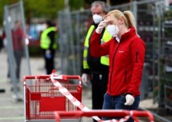 Employees of a garden store prepare the entrance for customers in Munich, Germany, Monday, April 20, 2020.