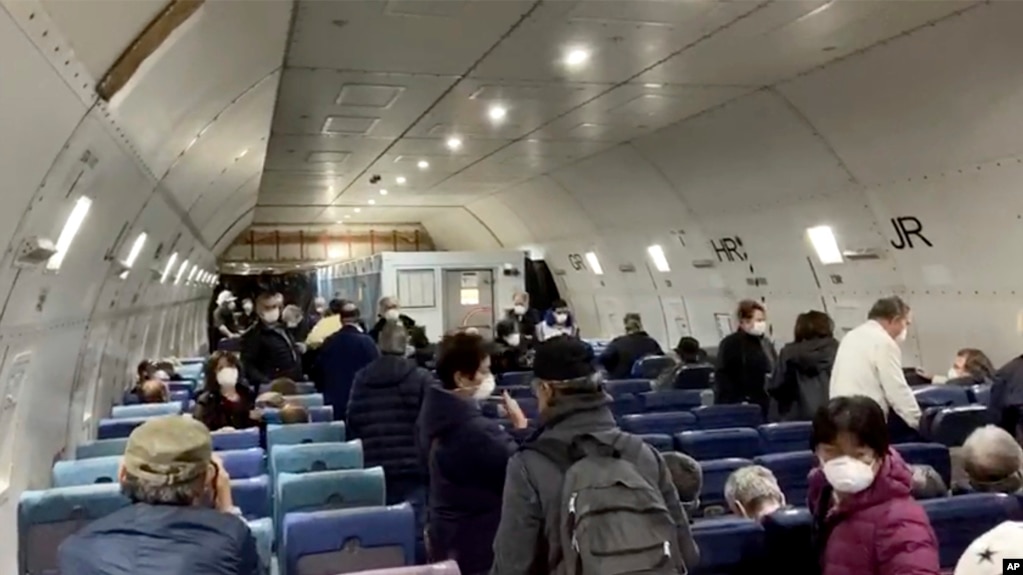 Imagen tomada de un video el lunes 17 de febrero de 2020, pasajeros del crucero en cuarentena Diamond Princess esperan a volar hacia Estados Unidos desde el aeropuerto de Haneda, en Tokio. (Cheryl y Paul Molesky via AP)