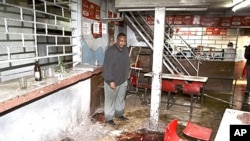 Pub-owner Charles Mwaura observes the bloodstained floor at the scene of a suspected grenade blast at his pub in downtown Nairobi, Kenya, October 24, 2011.