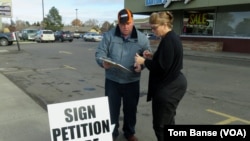 Marie Christopherson of Buhl, Idaho, stopped to sign Rick Martin's petition to ban refugee centers in Twin Falls County.