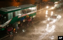 Stanovnici Manile pokušavaju da se zaštite od kiše i udara vetra koje je doneo tajfun Manghut.