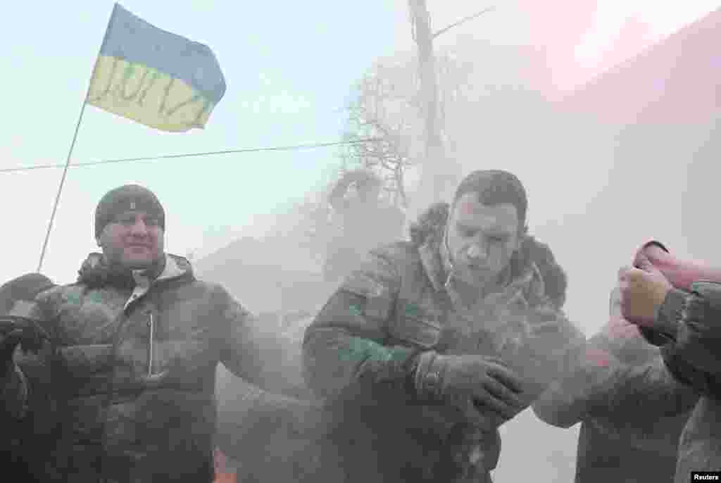 Ông Vitaly Klitschko (giữa), nhà lãnh đạo đối lập Ukraina bị xịt bằng bình chữa cháy bột trong cuộc biểu tình trong thủ đô Kyiv của Ukraina, ủng hộ việc hội nhập khối EU, 19/1/14