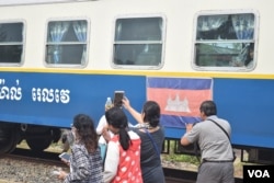 Excited tourists take photographs of a train during a break at Kampot station. (D. de Carteret/VOA)