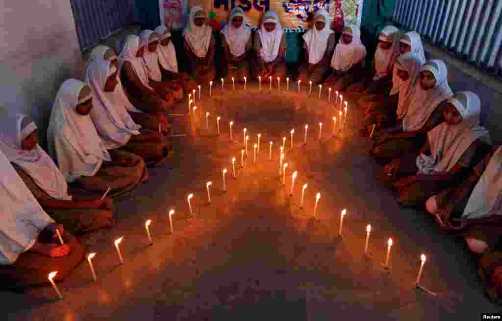 School girls light candles in the shape of a ribbon during a HIV/AIDS awareness campaign ahead of World Aids Day, in Ahmedabad, India, Nov. 30, 2016.