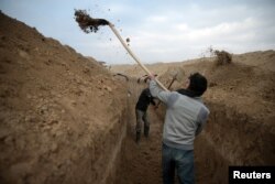 Rebel fighters dig a trench on the forth day of the truce, on al-Rayhan village front near the rebel held besieged city of Douma, in the eastern Damascus suburb of Ghouta, Syria Jan. 2, 2017.
