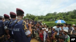 Anak-anak pengungsi Rohingya menyaksikan para pejabat Myanmar dan China tiba di kamp Nayapara di Cox's Bazar, Bangladesh, 22 Agustus 2019.