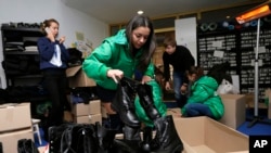 Ukrainian volunteers packing military boots to be sent to government soldiers waging combat against pro-Russian separatists in eastern Ukraine in Kyiv, Friday, Nov. 14, 2014.