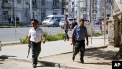 FILE - Police officers secure an area in the capital of Tajikistan, Dushanbe, where several Interior Ministry officers were shot dead earlier on Sept. 4, 2015, in attacks reportedly mounted by groups led by disaffected deputy defense minister Abdukhalim Nazarzoda.