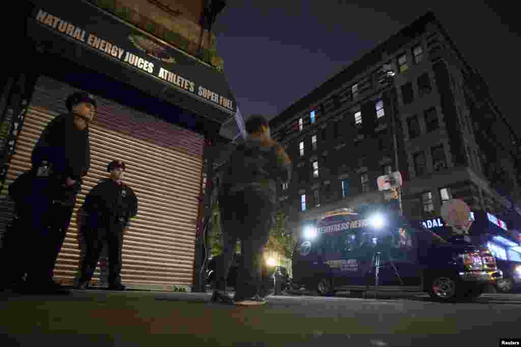 Police stand guard across the street from Dr. Craig Spencer&#39;s apartment, after it was confirmed that he tested positive for Ebola, New York City, Oct. 23, 2014. 