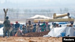 土耳其士兵在和敘利亞邊境附近的一個難民營站崗。