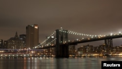The Brooklyn Bridge is seen before the lights are turned off, in participation with Earth Hour, in New York March 31, 2012. Lights started going off around the world on Saturday in a show of support for renewable energy. REUTERS/Allison Joyce (UNITED STAT
