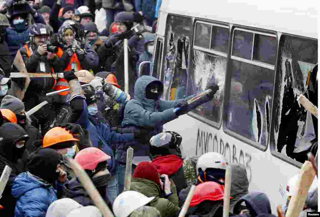 Người biểu tình Ukraina ủng hộ hội nhập châu Âu tấn công chiếc xe cảnh sát trong cuộc biểu tình ở Kyiv, 19/1/14