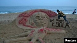 Seniman pasir Sudarshan Pattnaik membuat patung dengan pesan terkait Ebola di pantai di Puri, negara bagian Odisha di India timur (17/10).