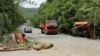 A car passes by trucks used as barricades after Kosovo police cleared the road near Zubin Potok, Kosovo, May 28, 2019.